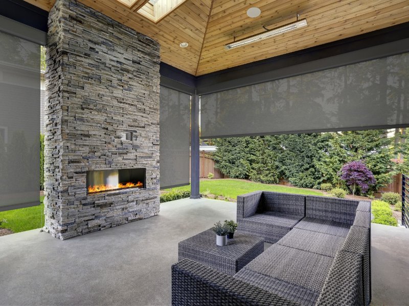 Outdoor patio with roller shades and fireplace